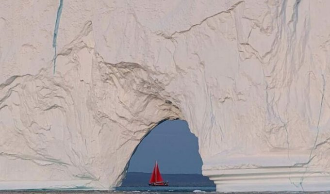 Крошечная лодка проплывает возле огромного айсберга (4 фото)
