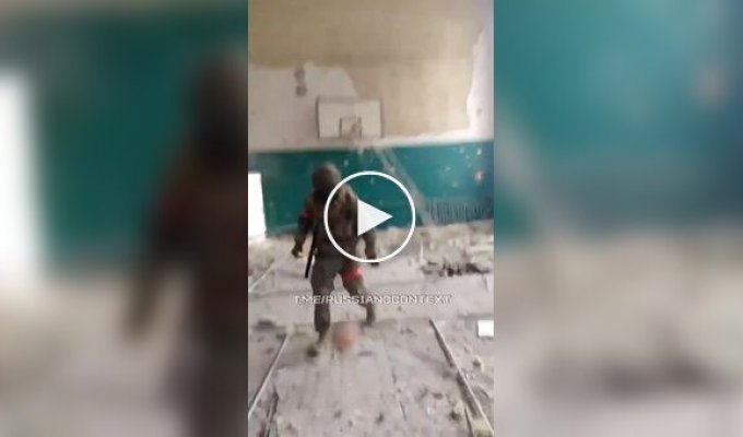 Occupiers play basketball among black bags with the bodies of their fellow soldiers in a dilapidated gym