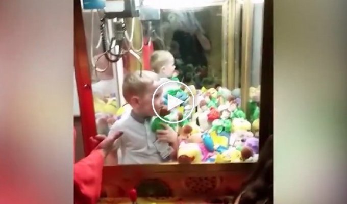 Маленький мальчик застрял в автомате с игрушками