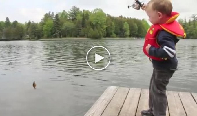 Маленький мальчик поймал первую рыбку