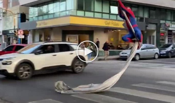 An eccentric in a Spider-Man costume entertains passers-by