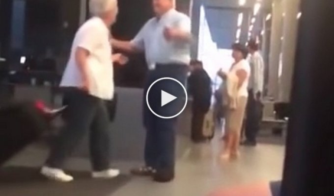 Дедушка встречает бабушку в аэропорту с цветами