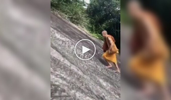 Монах поднимается по крутому склону без страховки