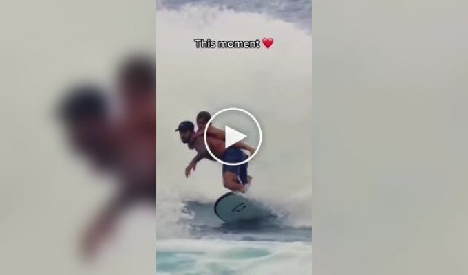 A surfer catches a wave with his son