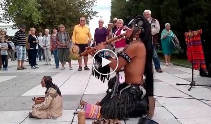 Мужчина из индейского племени играет кавер на Последний из могикан