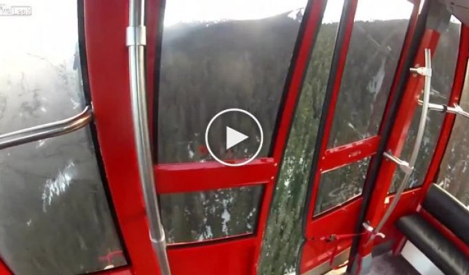 Прыжок парашютиста из вагонетки на канатной дороге