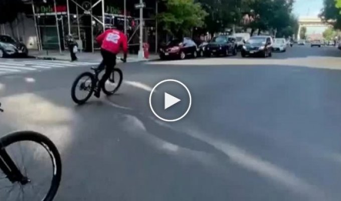 Black man demonstrates his bike riding skills but is interrupted