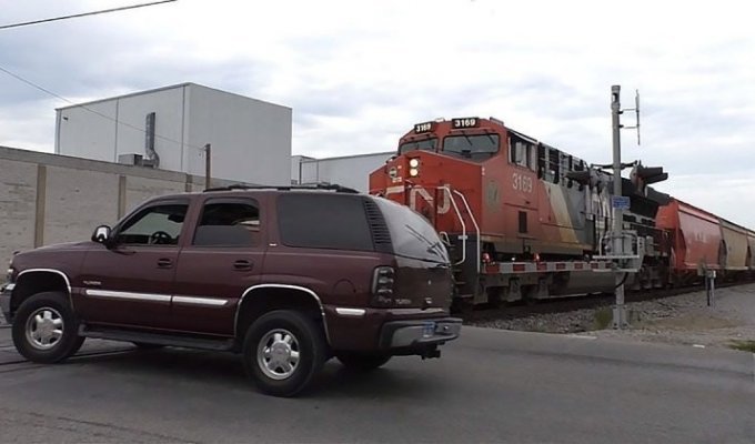 Поезд против Chevrolet Tahoe: водитель не стал дожидаться, пока поднимется шлагбаум (2 фото + 1 видео)