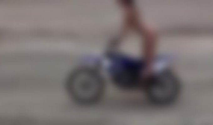 A girl rides a motorcycle without protection
