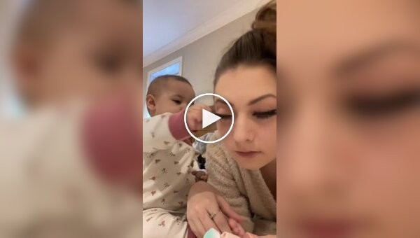 The baby showed that he is for naturalness by trying to rip out his mother's false eyelashes